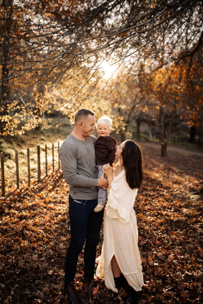 Family enjoying autumn leaves on a sunny day, Hawkes Bay family photographer capturing joyful moments
