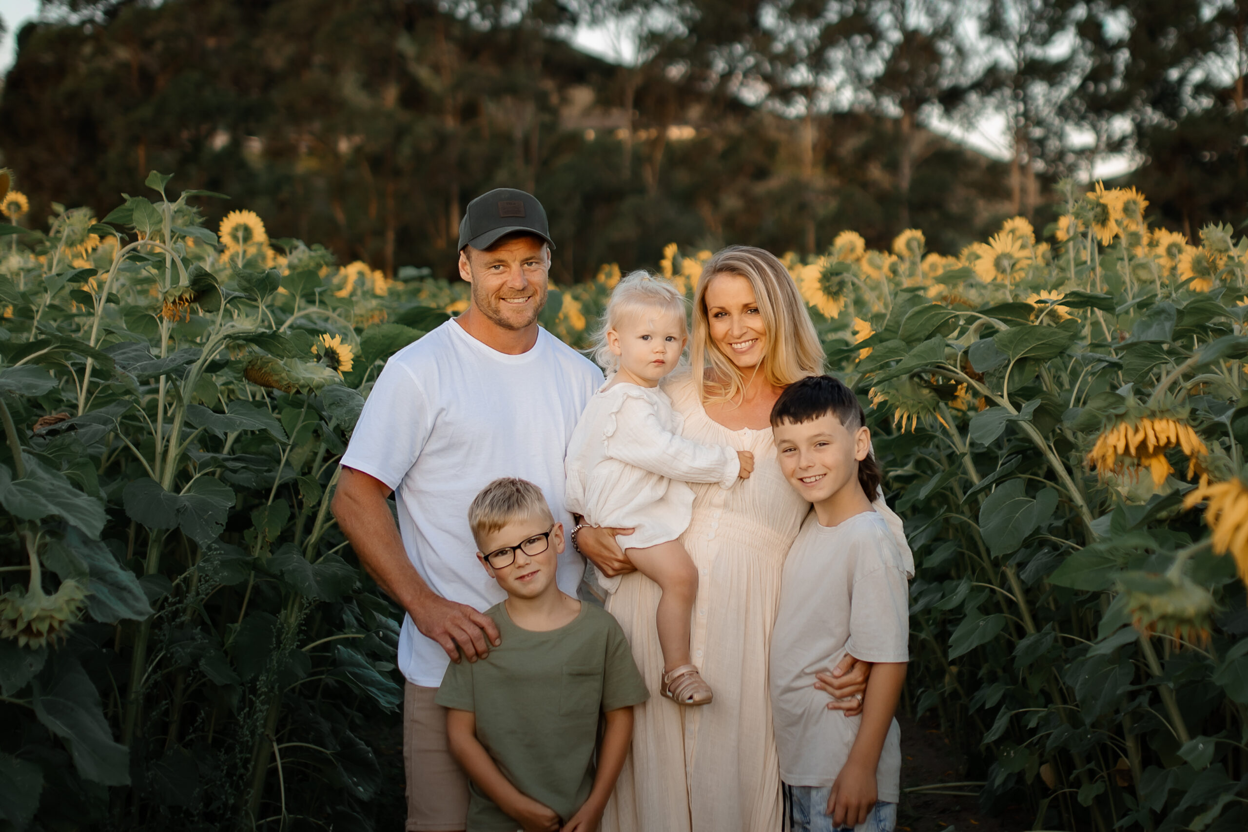 Family enjoying sunset in sunflower field in Hawkes Bay, photographed by Hawkes Bay photographer